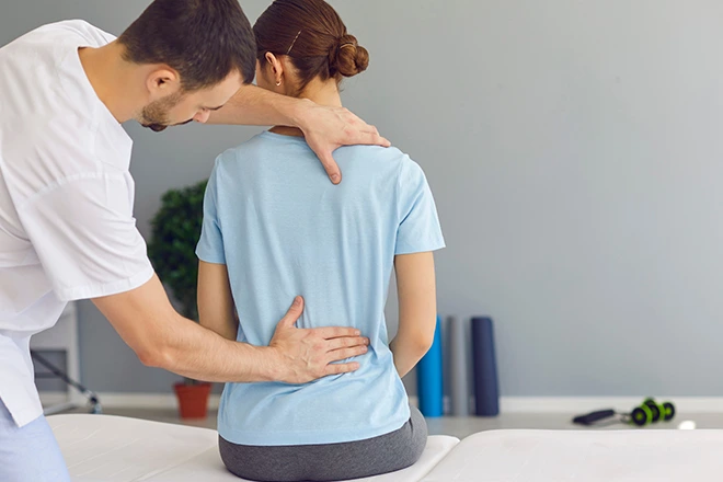 Chiropractor performing soft tissue therapy on a patient's back.