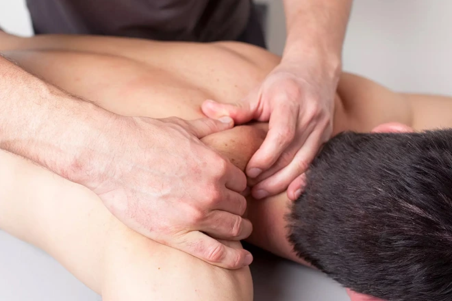 Myofascial Massage therapist working on a client's upper back and shoulders